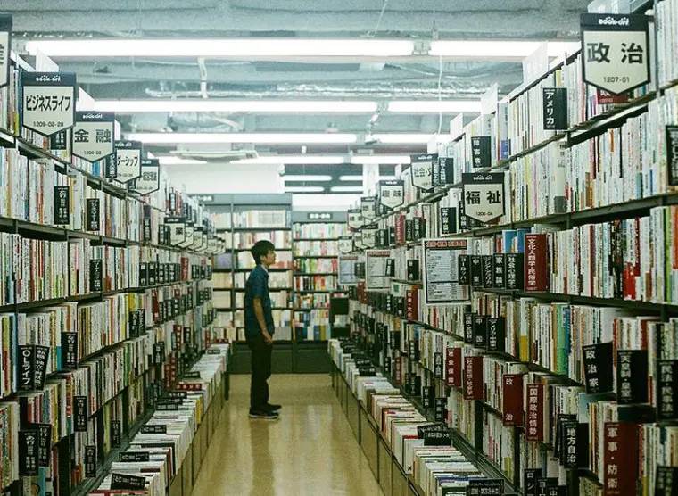 日本古本屋書店內顧客在書架間揀書